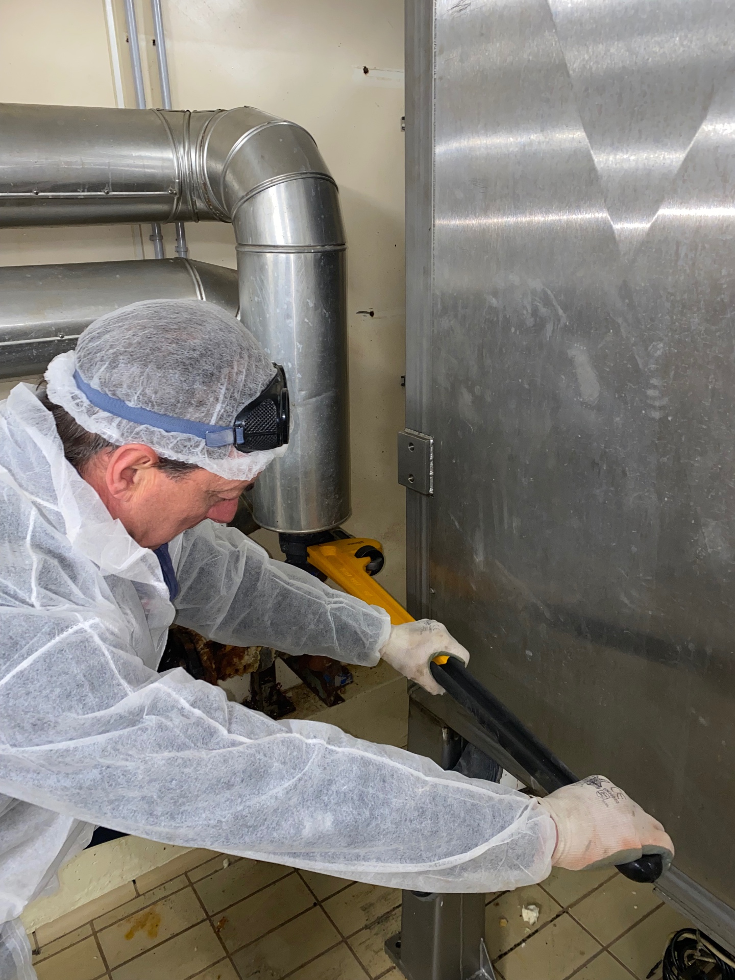 Tecnico al lavoro su una conduttura in un ambiente industriale